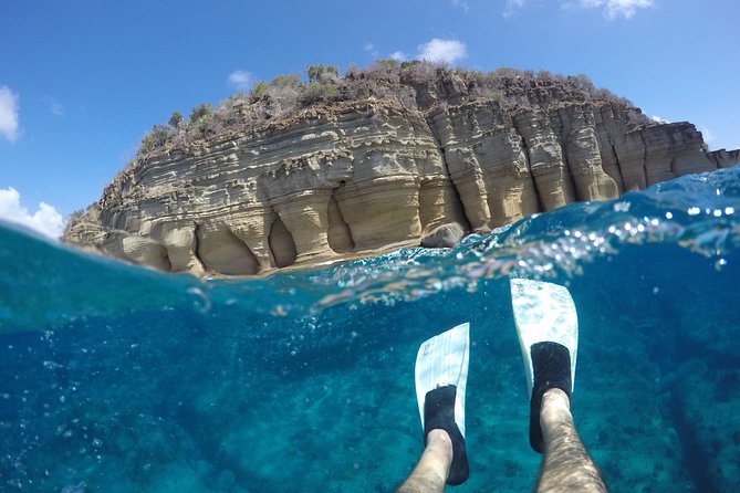 Snorkellers beneath the limestone cliffs on Antigua&rsquo;s east coast